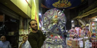 "ونحلو بإيه".. غلاء الأسعار يُفقِد عروسة المولد فرحتها عامل يحمل عروسة المولد (أرشيفية - ا ف ب)