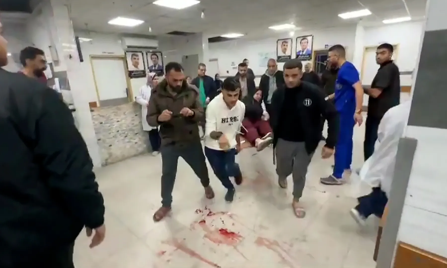 فلسطينيون ينقلون مصابًا داخل المستشفى (الجزيرة)