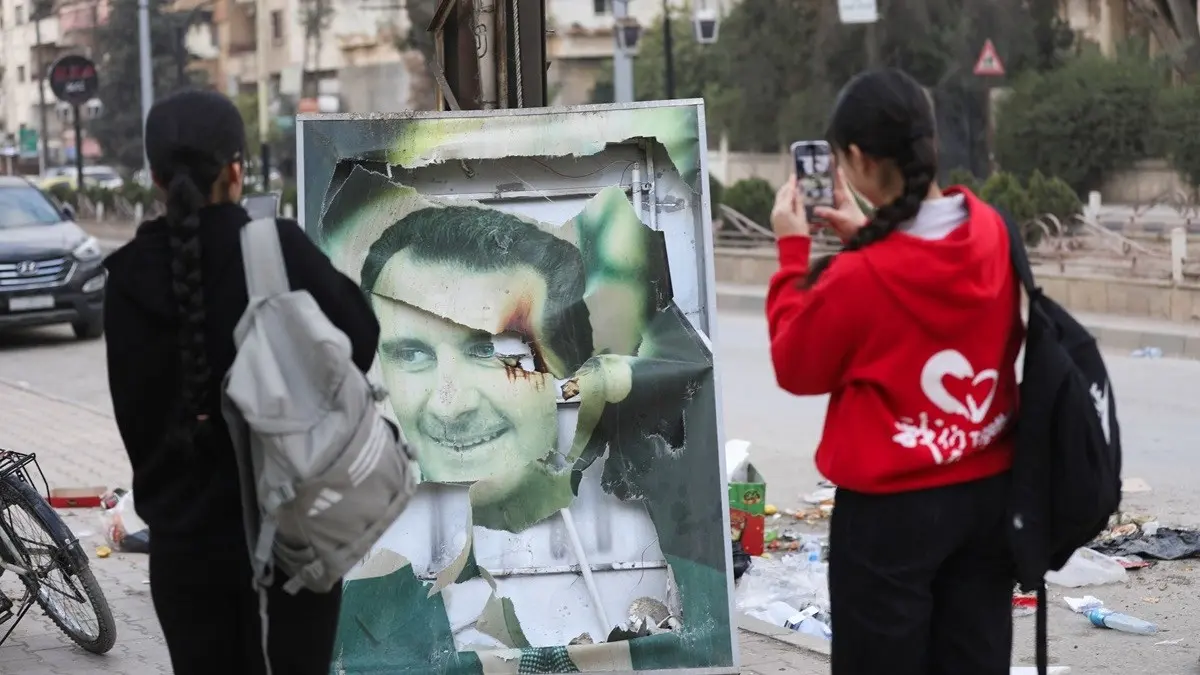 صورة ممزقة لبشار الأسد (وكالات)
