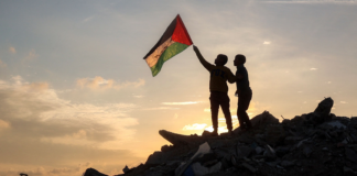 هل يستمر وقف إطلاق النار في غزة؟ طفلان من قطاع غزة يحمل أحدهما علم فلسطين (وكالات)