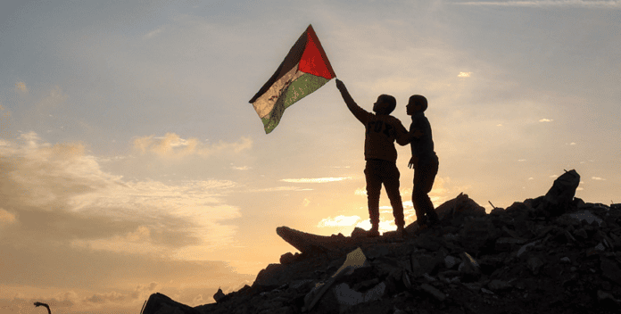 طفلان من قطاع غزة يحمل أحدهما علم فلسطين (وكالات)