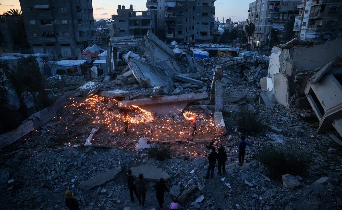 فلسطينيون يحتفلون بين ركام المنازل المدمرة في غزة بوقف إطلاق النار (وكالات)