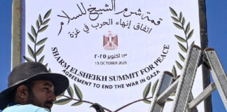 قمة شرم الشيخ| خطة غزة والاصطدام بفخ "نعم ولكن" عامل يثبت لافتة في شرم الشيخ، بينما تستعد المدينة المصرية لاستضافة قمة السلام الخاصة بغزة برعاية أمريكية، في 13 أكتوبر 2025 (أ ف ب)